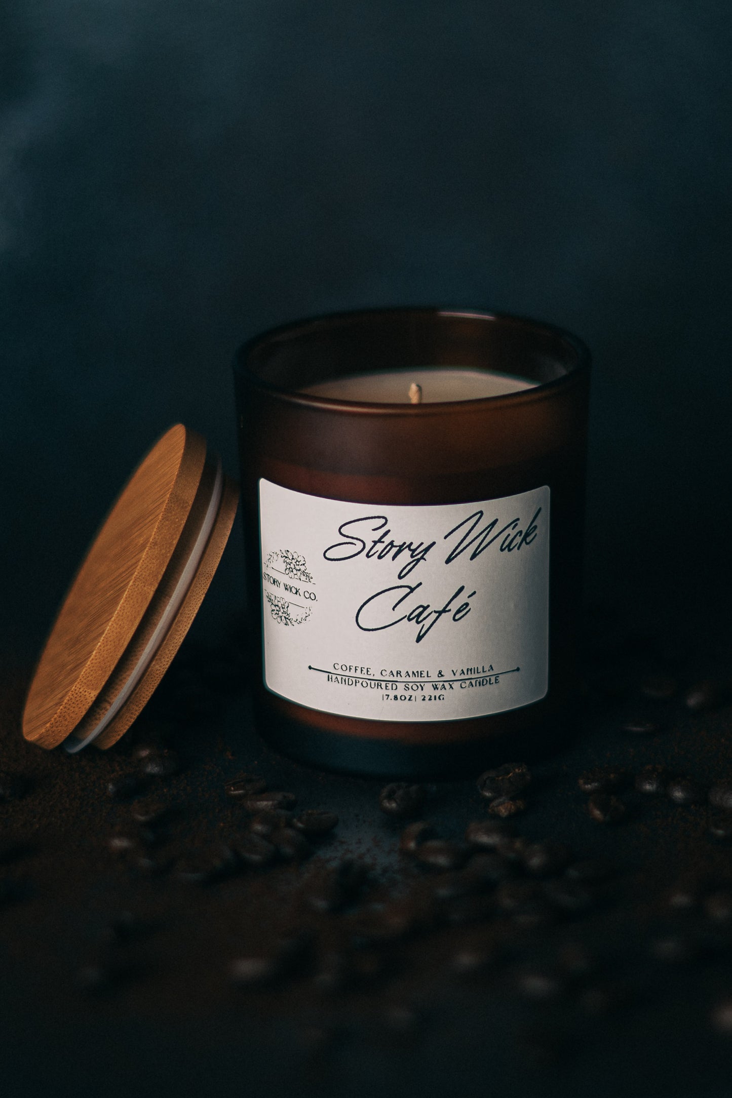 Candle with a label titled 'Story Wick Cafe' on a dark background with coffee beans