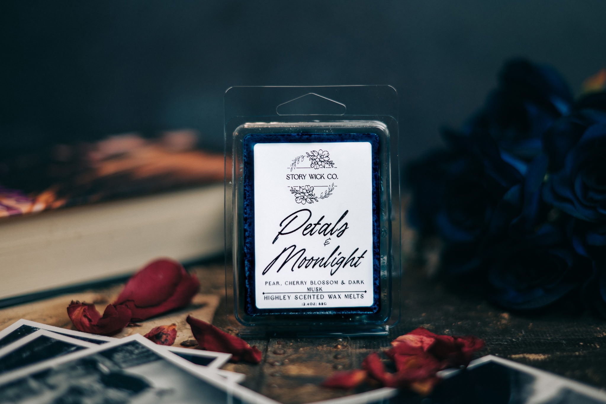 Story Wick Petals & Moonlight wax melt packaging with dried roses and a book in the background