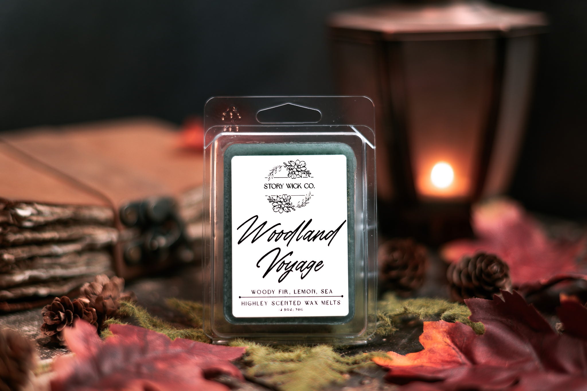 Wax melt package labeled 'Woodland Voyage' on a decorative surface with candles and nature-themed elements..