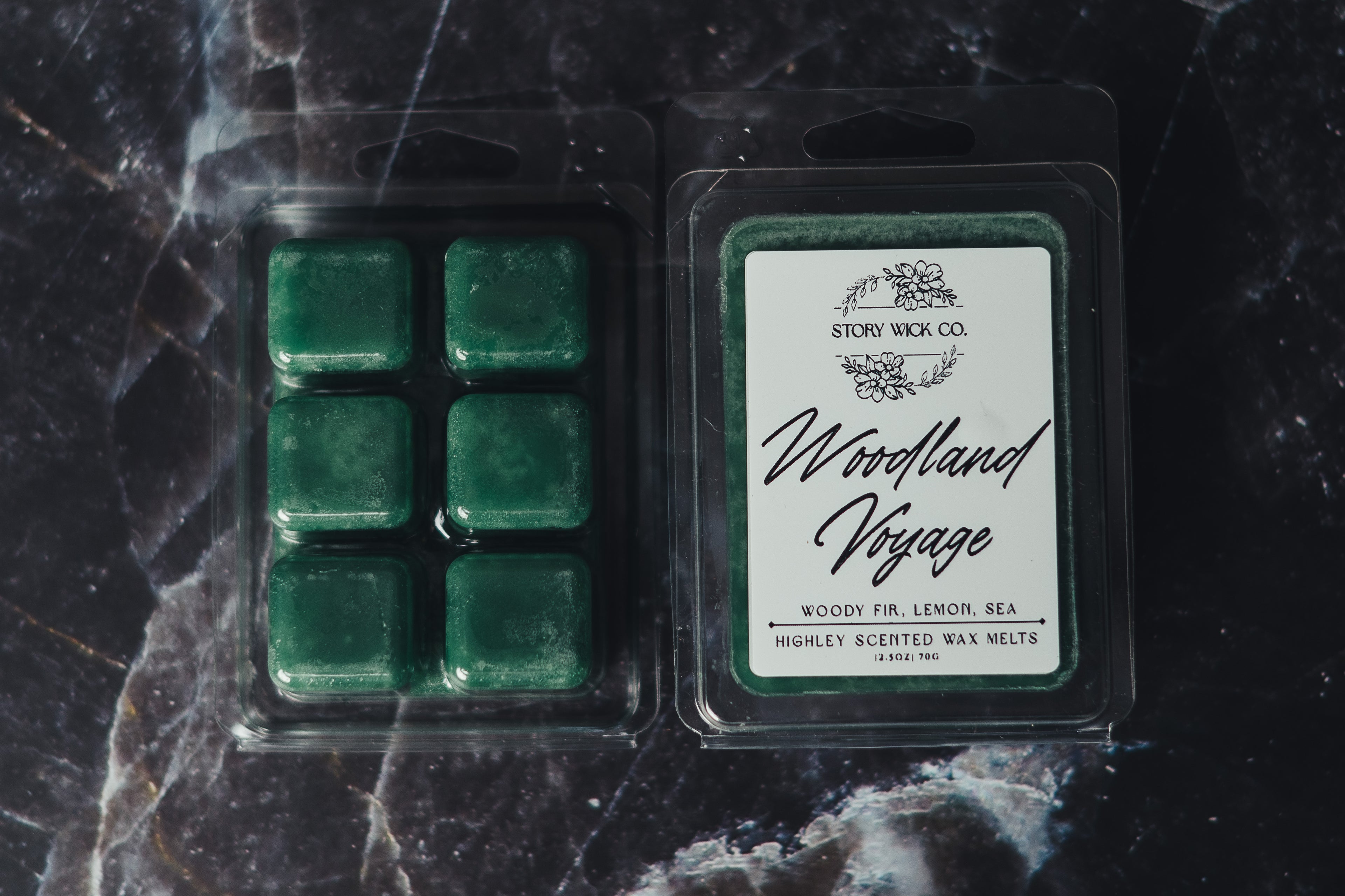 Packaged green wax melts with a label on a dark marble surface.