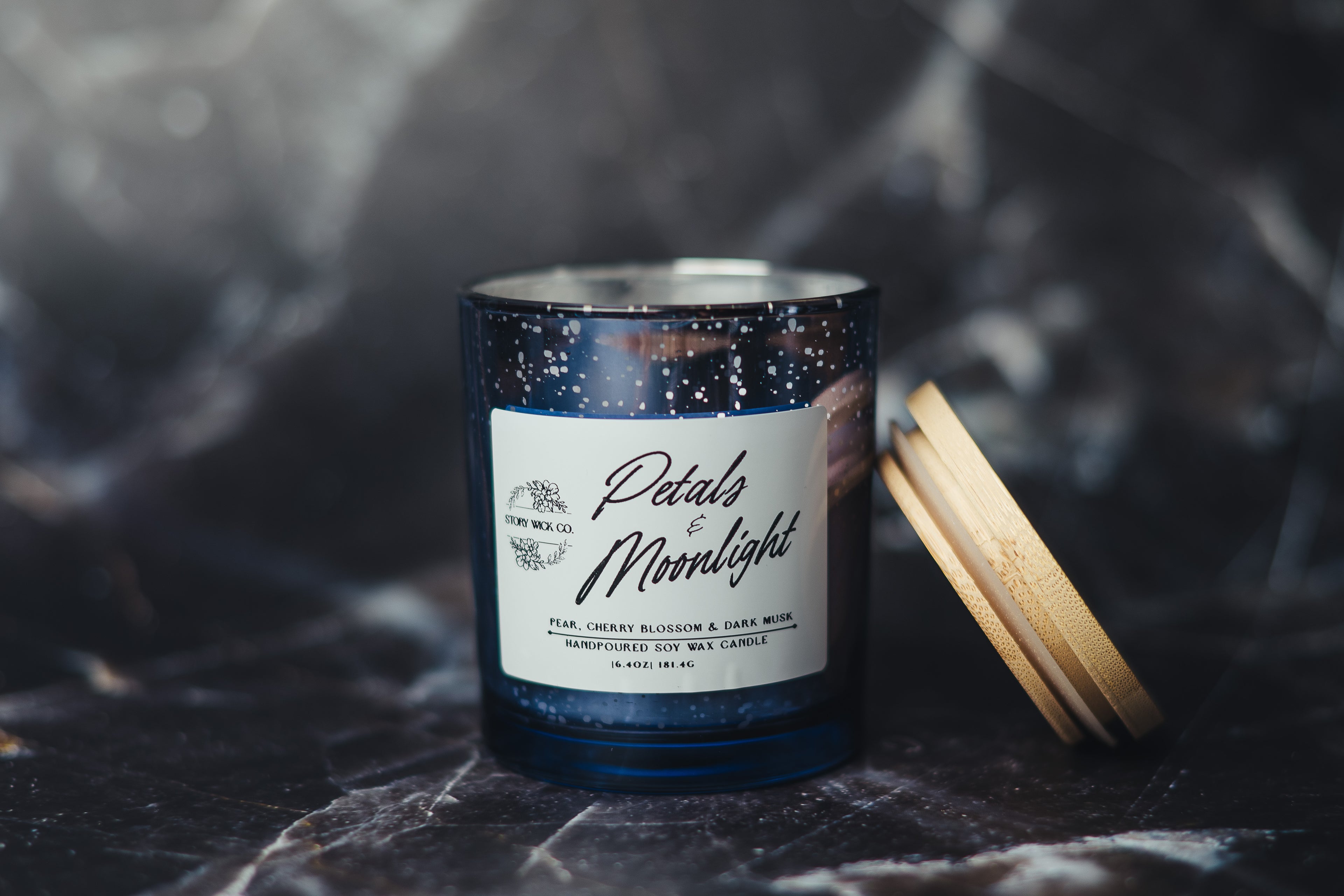 Candle with a label on a dark textured surface