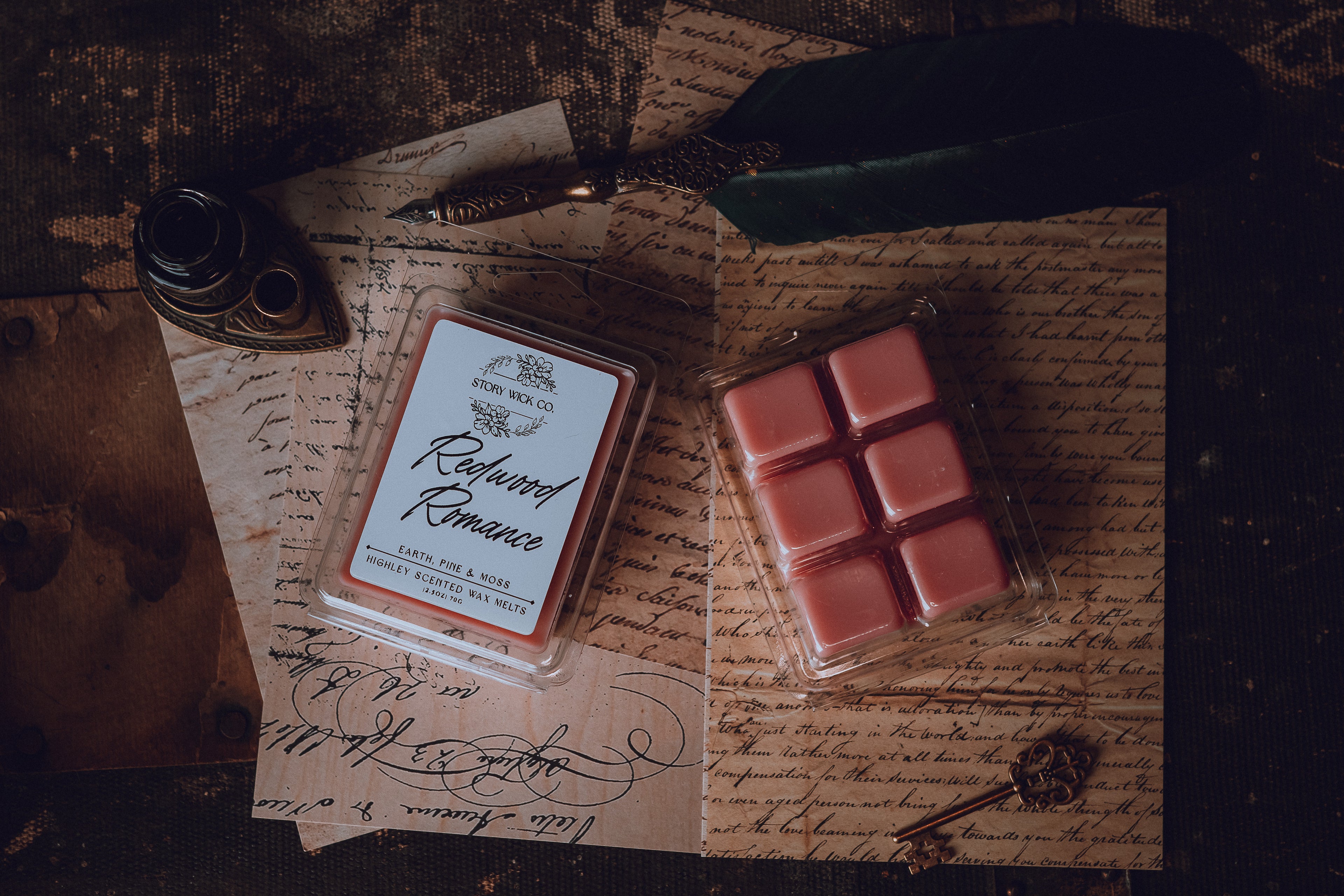 Two small containers of wax melts on a surface with vintage-style text and a feather.