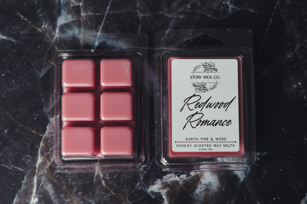 Pack of redwood romance wax melts on a dark marble surface