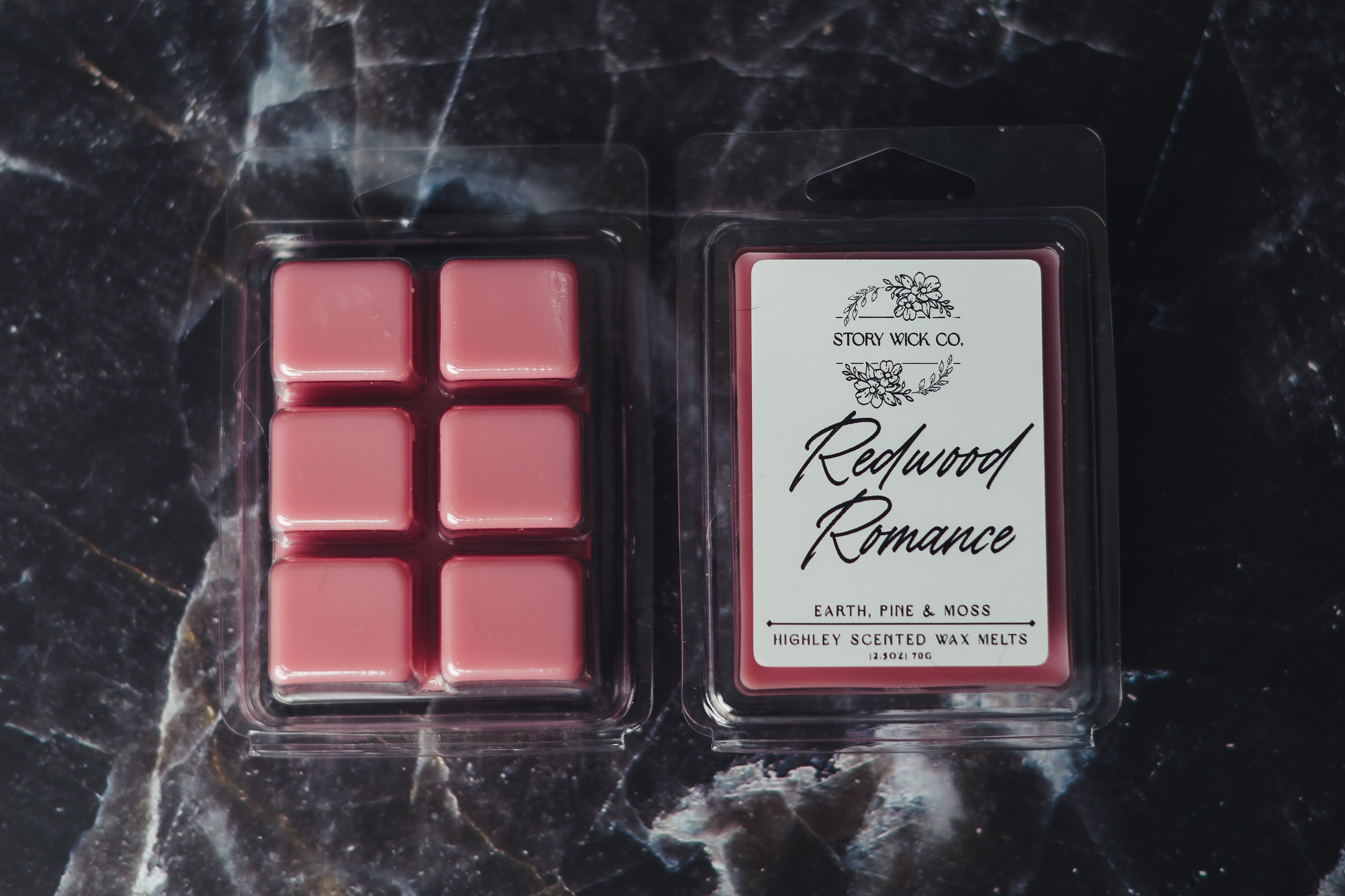 Pack of redwood romance wax melts on a dark marble surface