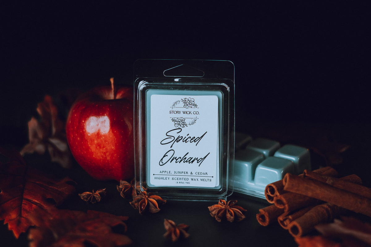 Spiced Orchard wax melt package with an apple, cinnamon sticks, and star anise on a dark background