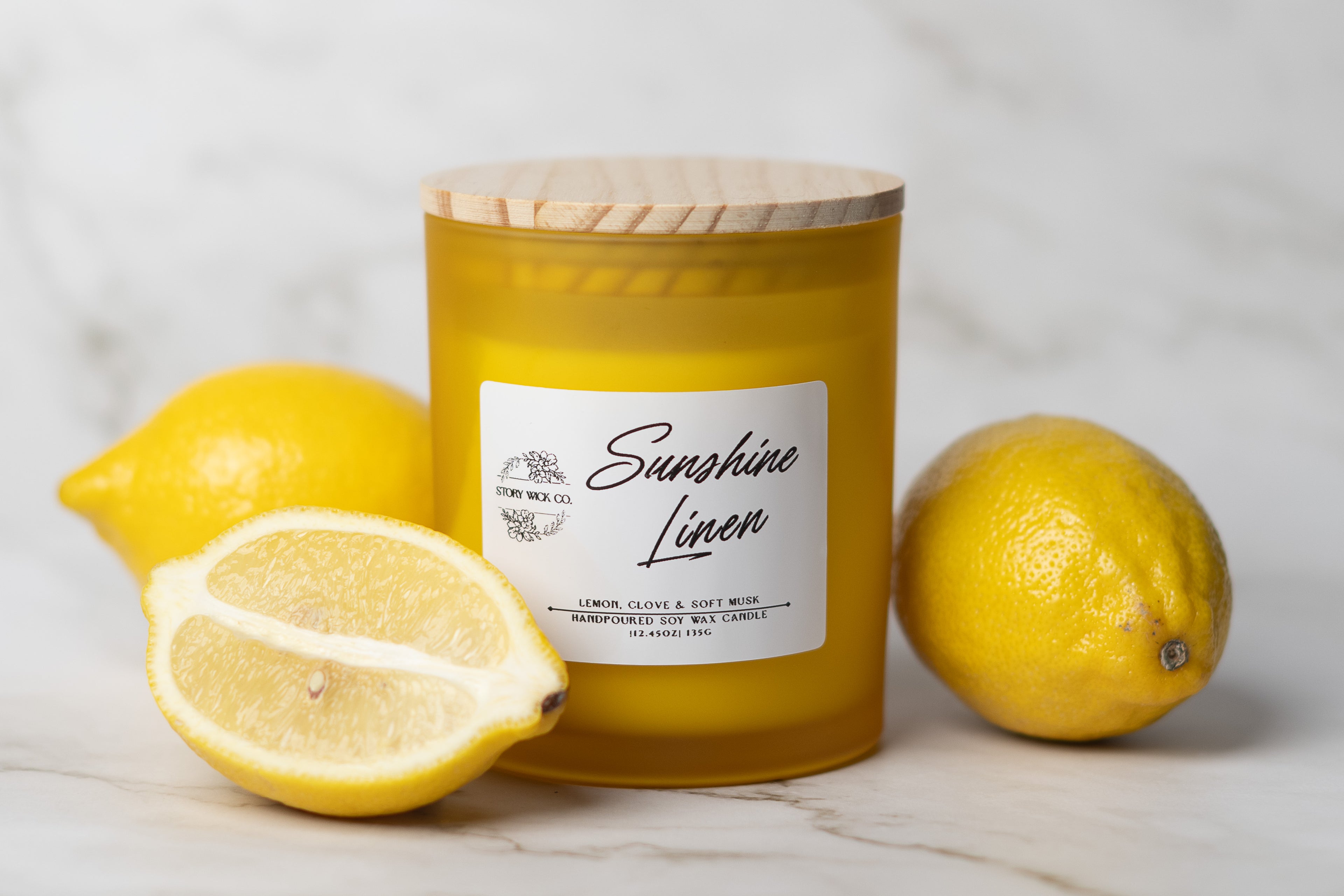 Candle labeled 'Sunshine Linen' with lemons on a light background.